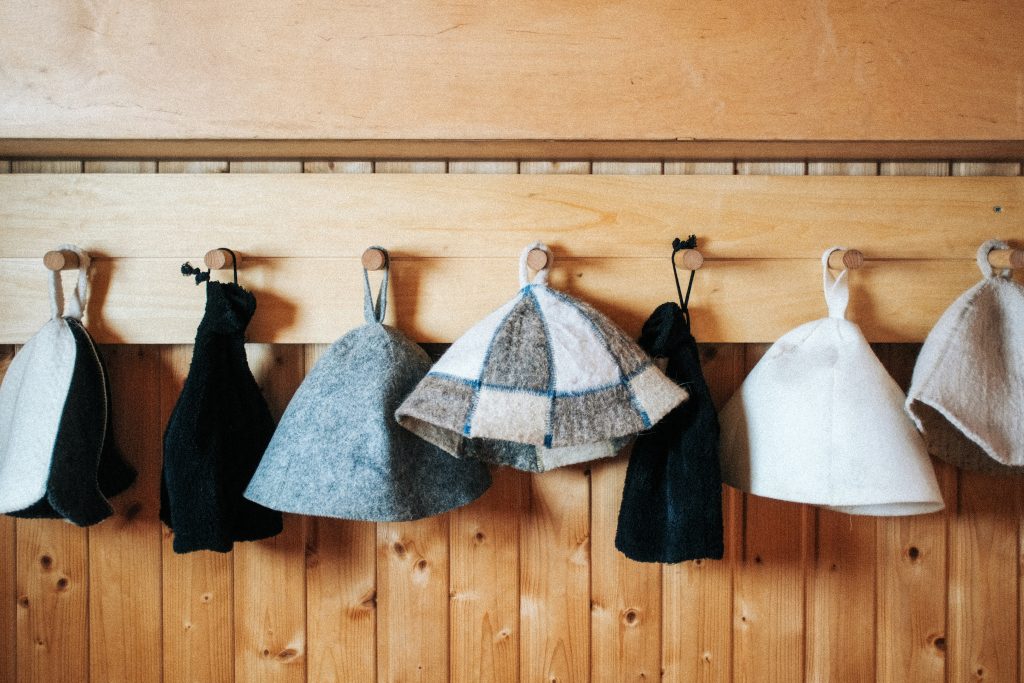 Organized row of soft towels hanging on wooden hooks inside the cedar sauna, enhancing guest convenience and comfort