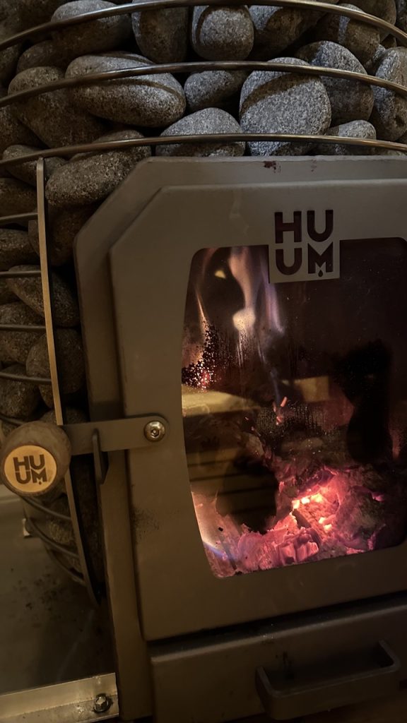 Bliss Mobile Sauna wood-burning heater glowing with warmth, showcasing the craftsmanship of its design