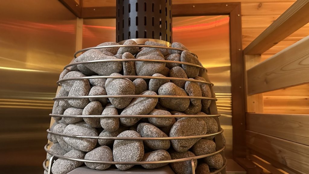 Efficient wood-burning sauna heater surrounded by cedar panels, delivering authentic heat and relaxation for Bliss Mobile Sauna