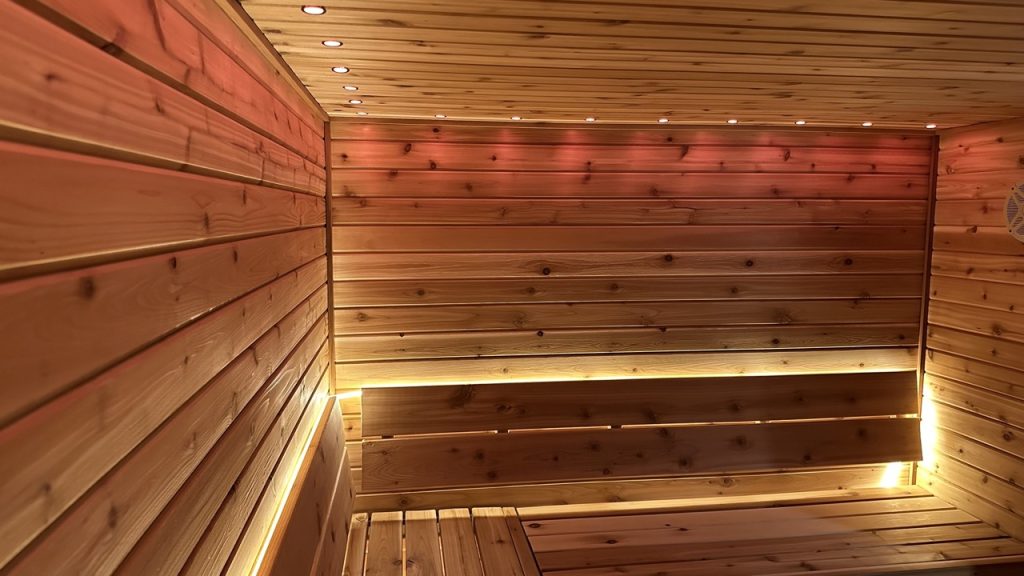 Beautiful cedar sauna interior with warm lighting, showcasing Bliss Mobile Sauna’s handcrafted design and luxury features