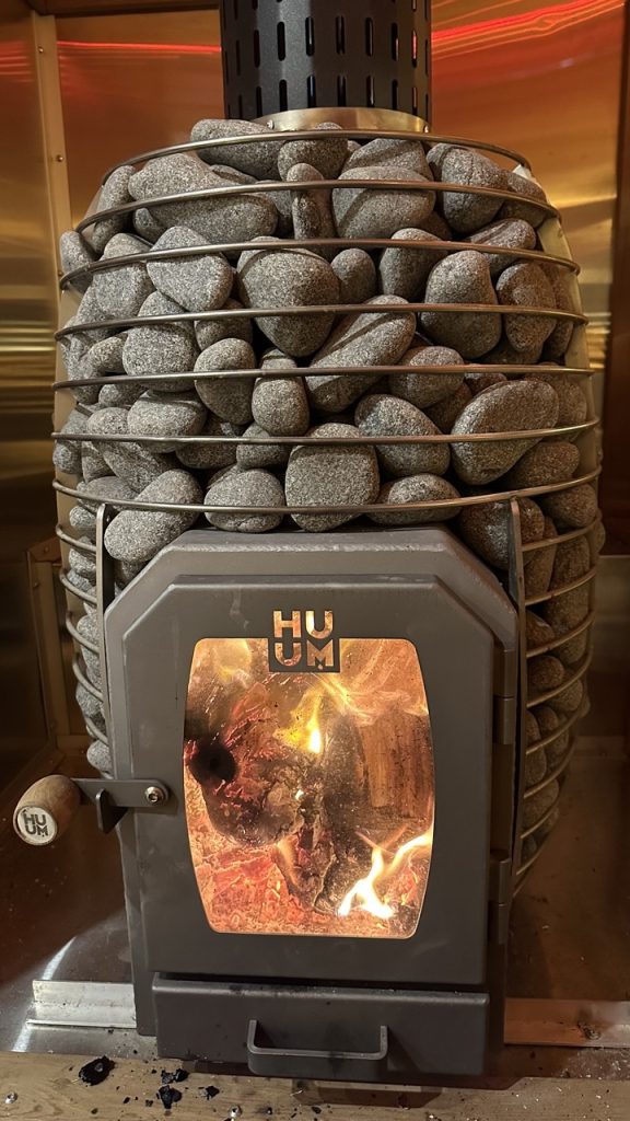 Authentic wood-burning sauna heater providing steady warmth for a luxury sauna rental in Edmonton.