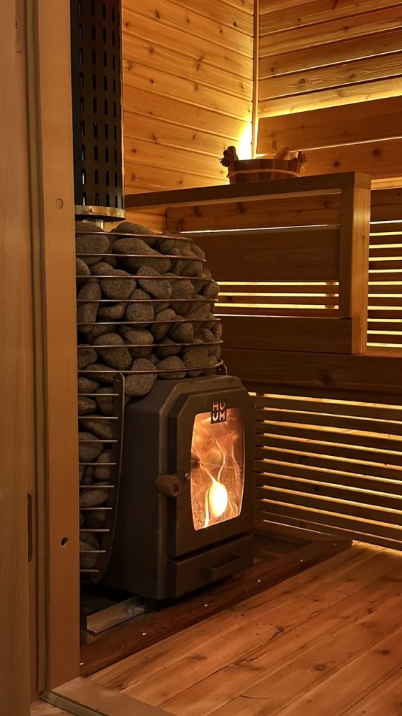 IMG_8323 Large Exterior view of a glowing wood-burning heater, part of the Bliss Mobile Sauna setup